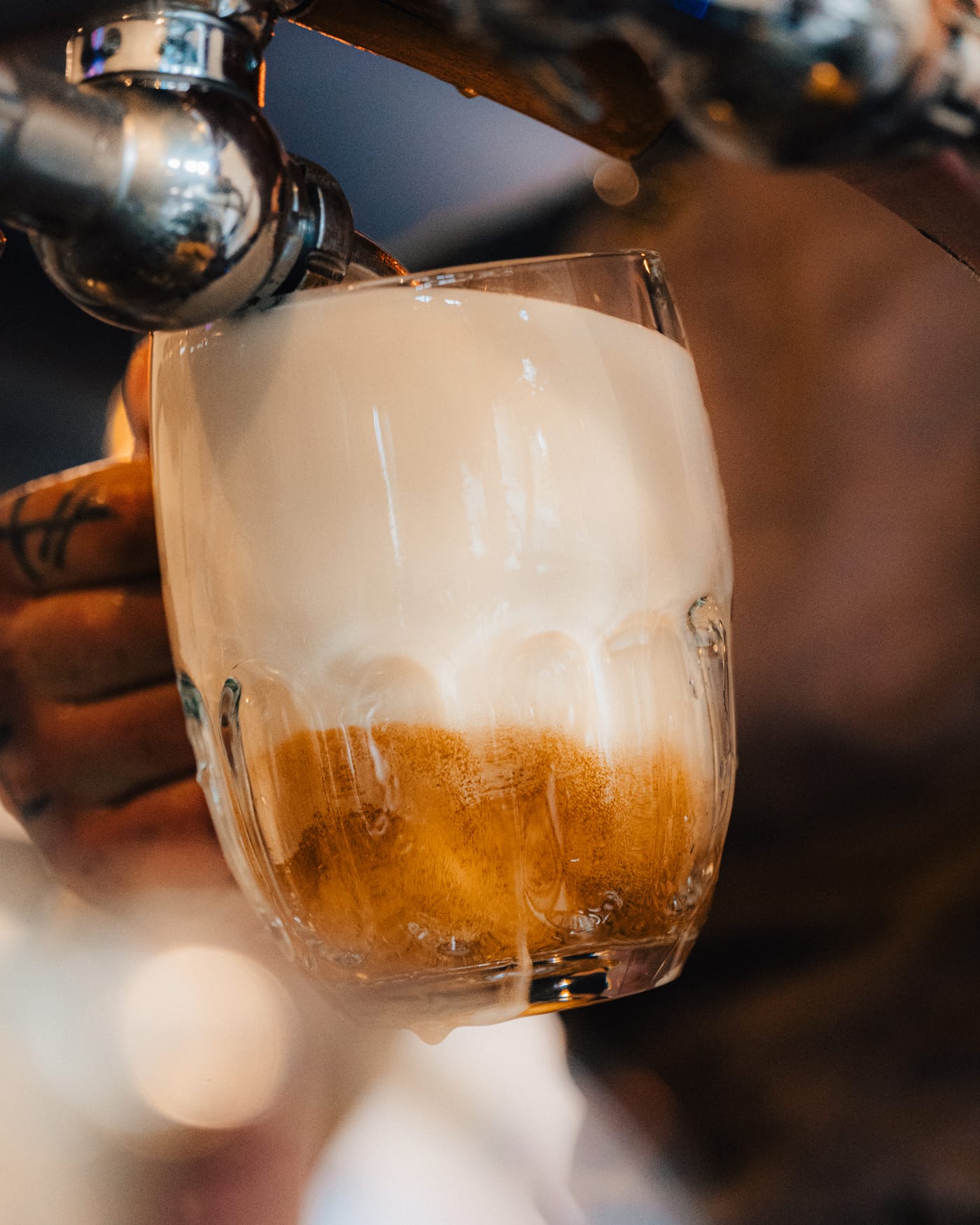 Čepování Pilsner Urquell – pěna přetéká přes okraj půllitru